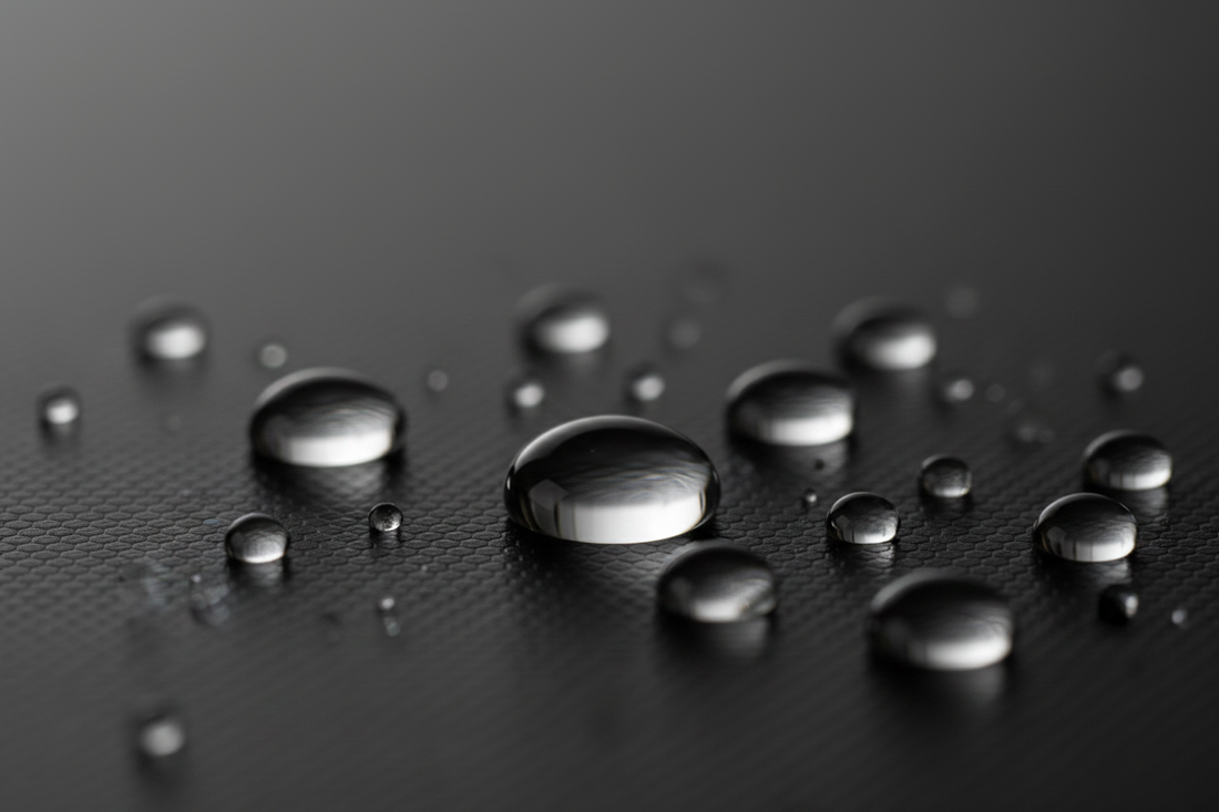 Water droplets of varying sizes beading on a hydrophobic nano-coated surface
